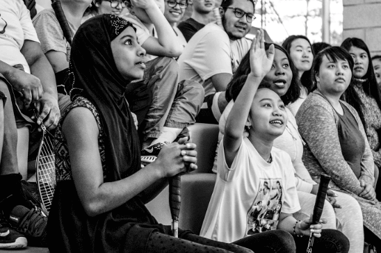 Group of kids sitting with one kid raising his hand