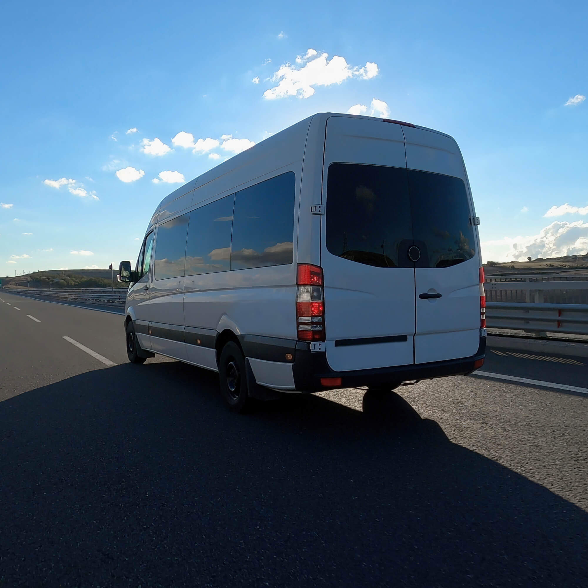 white van driving on the road