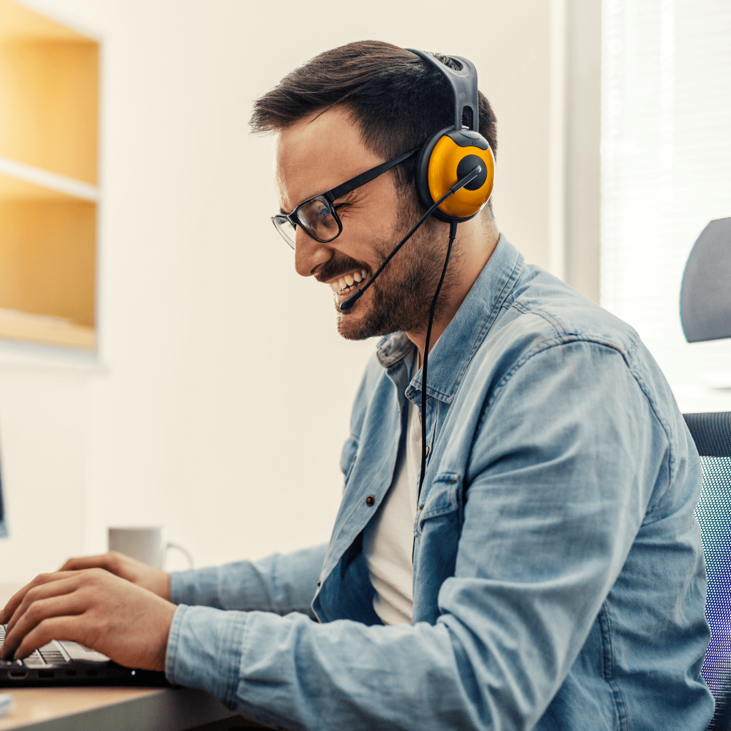 Young cheerful male operator with headset in the office